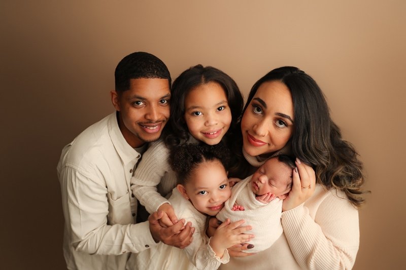 Parents and two big sisters holding their newborn, family newborn portrait